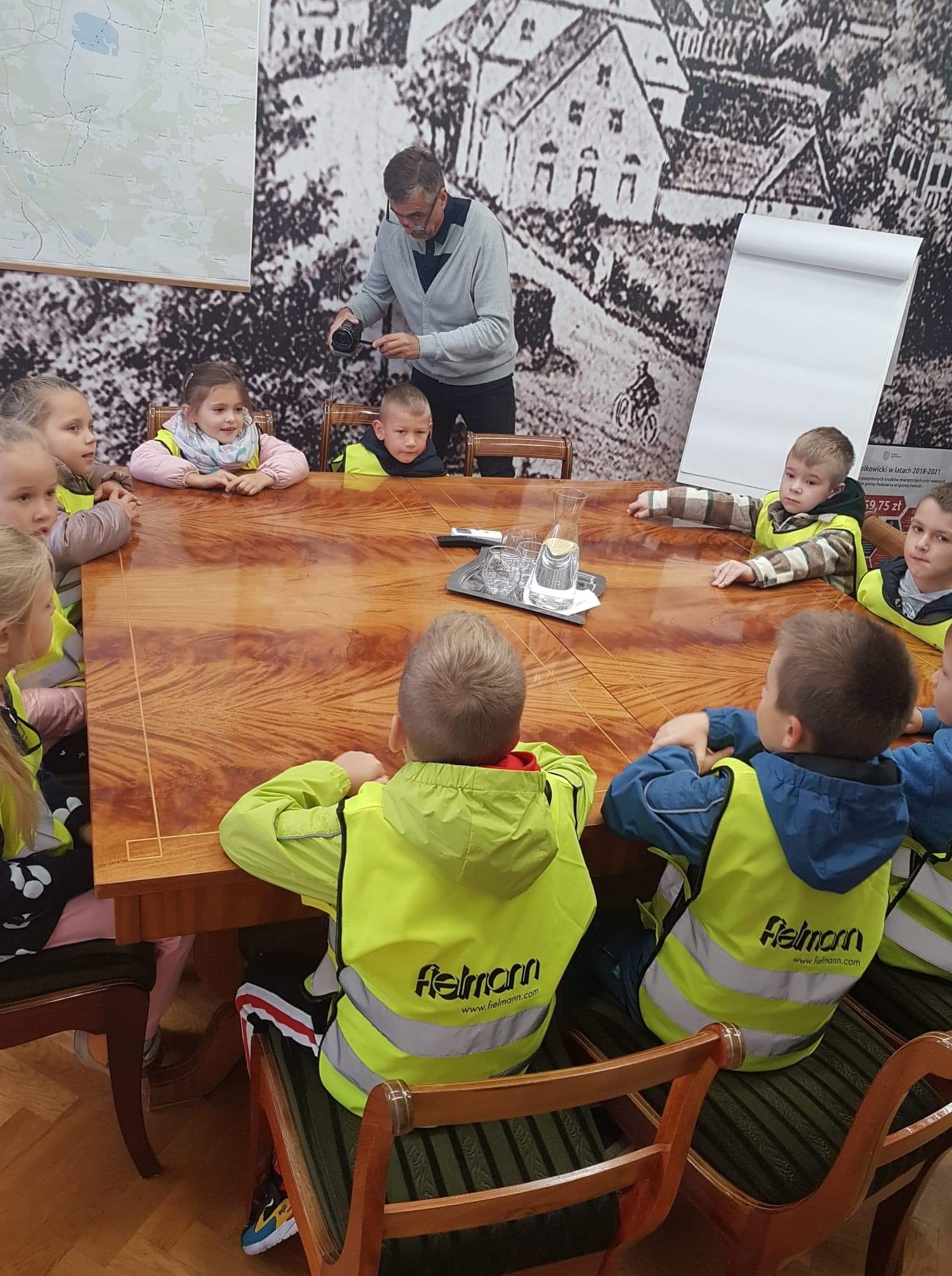 Dzieci siedzą przy stole w Urzędzie Gminy