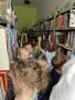 Dzieci stoją pomiędzy regałami z książkami w bibliotece.